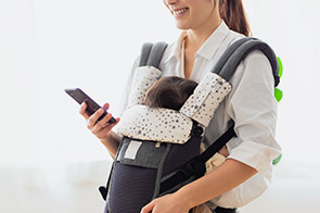 抱っこ紐でスマホを使う親